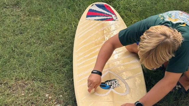 Waxing my surfboard on the grass before a session